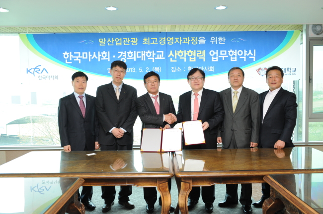 한국마사회 이중호 본부장과 경희대 관광대학원 김철원 원장이 협약서에 사인한 뒤 악수를 나누고 있다. 사진=한국마사회