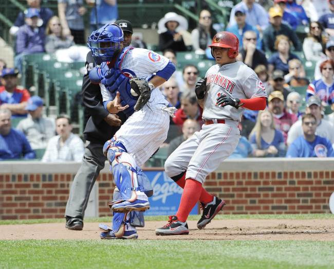 Choo Shin-soo (right) of the Cincinnati Reds scores a run as Welington Castillo of the Chicago Cubs takes a late throw during the third inning at Wrigley Field in Chicago, Illinois, Saturday.    AFP-Yonhap News