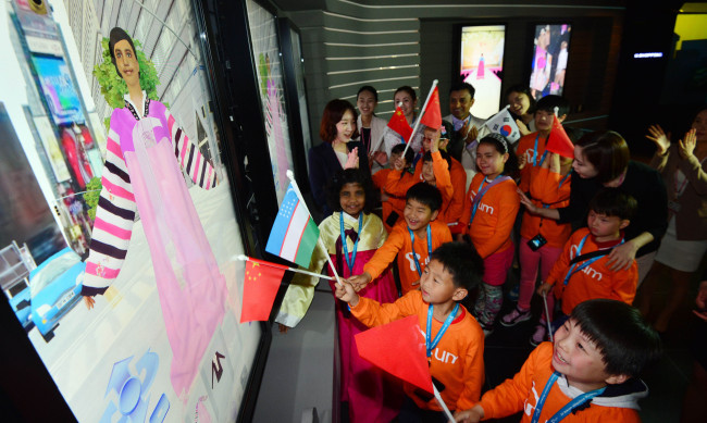 Children from multicultural families try out advanced technology during their visit to SKT’s Ubiquitous Museum at its headquarters on Monday. The company invited them in celebration of Children’s Day, which fell on May 5.   Kim Myung-sub/The Korea Herald