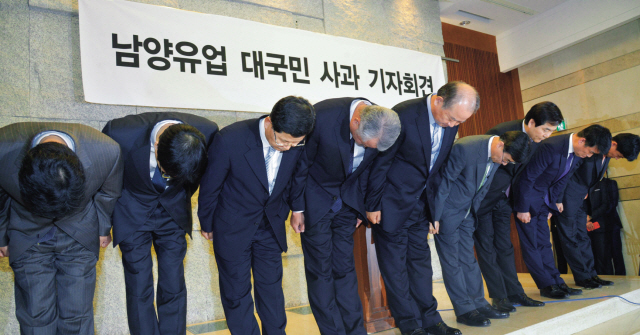 Namyang Dairy president Kim Woong (fifth from left) and executives bow to apologize for the abuse scandal involving its employee during a news conference in Seoul on Thursday. (Kim Myung-sub/The Korea Herald)
