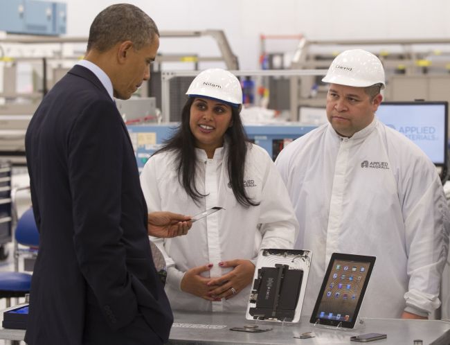 U.S. President Barack Obama holds a smartphone component while speaking with employees at Applied Materials, a manufacturer of systems for polishing the surface of unfinished semiconductor chips, in Austin, Texas, Thursday.   AFP-Yonhap News