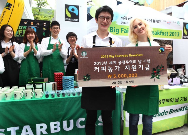 Starbucks coffee ambassador in Korea Choi Yong-seok (left) on Thursday signed up to donate 5 million won for smaller coffee producers to Bronwyn Mullen, a goodwill ambassador to Korea from the World Fair Trade Organization, in Sinsa-dong, southern Seoul, as a part of the company’s fair trade campaign for World Fair Trade Day, which is Saturday.   Starbucks