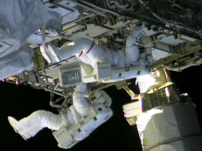 In this still image taken from NASA TV, International Space Station astronauts Chris Cassidy (top) and Tom Marshburn finish work on repairs to the ISS on Saturday.   AFP-Yonhap News