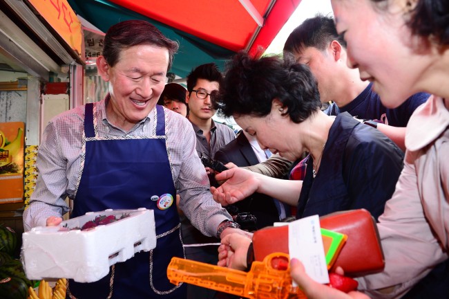 <YONHAP PHOTO-0901> 허창수 회장, 전통시장 상인 체험 (서울=연합뉴스) 최재구 기자 = 전국경제인연합회(전경련) 산업본부 등의 임직원 116명 전원이 12일 서울 시내 전통시장으로 흩어져 종일 상인 체험을 한 가운데 허창수 회장이 12일 오후 서울 영등포구 대림동 우리시장의 한 과일가게에서 직접 과일을 판매하고 있다. 2013.5.12 jjaeck9@yna.co.kr/2013-05-12 16:20:57/ <저작권자 ⓒ 1980-2013 ㈜연합뉴스. 무단 전재 재배포 금지.>
Huh Chang-soo, chairman of the Federation of Korean Industries and GS Group, serves as a one-day merchant selling fruits at a traditional market in Daelim-dong, southwestern Seoul, on Sunday. The FKI organized the experience program for its staff to share the difficulties facing traditional markets.   Park Hae-mook