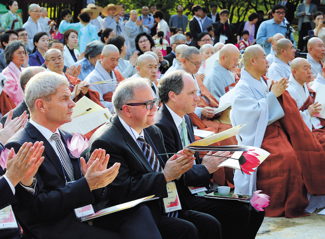 British Ambassador to Korea Scott Wightman (third from left), Bulgarian Ambassador to Korea Petar
Andonov (second from left) and German Ambassador to Korea Rolf Mafael (left) applaud during a
dinner reception for foreign envoys of countries that sent support to South Korea during the Korean
War at Jinkwansa Temple on Bukhansan Mountain in Seoul on Wednesday. Yonhap News
