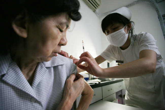 Nurse Ye Yu Jie gives a shot to a patient in a hospital in Shanghai, China.   Bloomberg