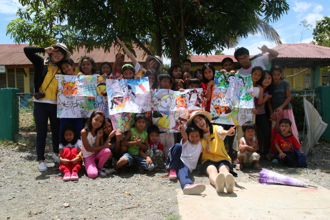 “RaonAtti,” a team of college volunteers organized by KB Kookmin Bank and YMCA Korea, pose with local children in the Philippines.   KB Financial Group