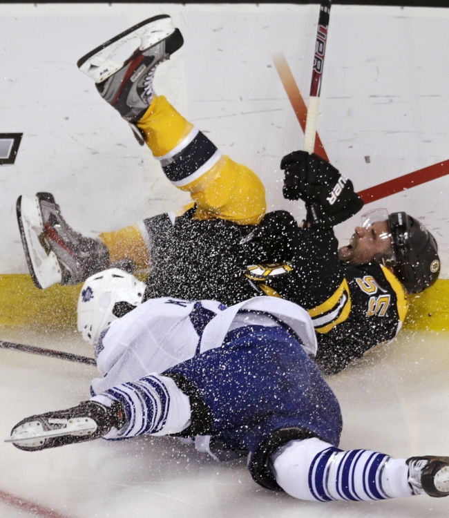 Toronto Maple Leafs center Nazem Kadri (bottom) and Boston Bruins defenseman Johnny Boychuk challenge for the puck on Monday.   AP-Yonhap News
