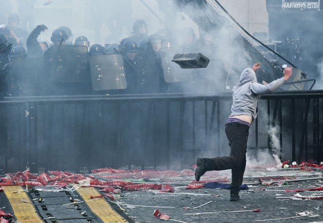<YONHAP PHOTO-0167> Supporter trow a concrete block toward riot police during Paris Saint-Germain soccer club celebrations for winning the the French league title at Trocadero Plaza in Paris, Monday, May 13, 2013. Paris Saint-Germain clinched its first French league title since 1994 by defeating Lyon 1-0 on Sunday. (AP Photo/Michel Euler)/2013-05-14 07:36:39/ <저작권자 ⓒ 1980-2013 ㈜연합뉴스. 무단 전재 재배포 금지.>
A PSG supporter throws a concrete block toward riot police in Paris on Monday.   AP-Yonhap News