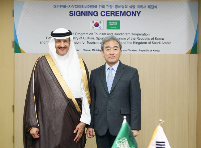 Prince Sultan bin Salman bin Abdulaziz bin Al-Saud (left) of Saudi Arabia poses with Culture Minister Yoo Jin-ryong after signing an agreement on handicraft and tourism exchanges at the ministry in Seoul on Monday.    Ministry of Culture, Sports and Tourism