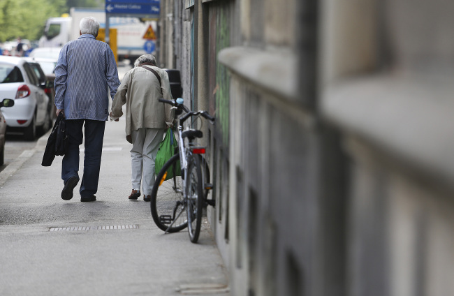 An elderly couple walk along a street in Ljubljana, Slovenia, Friday.   Bloomberg