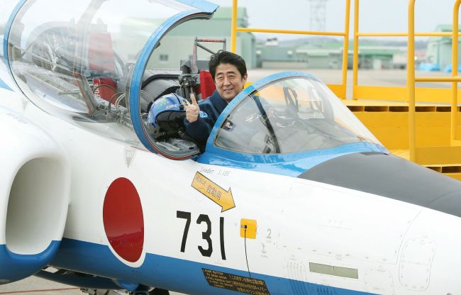 Japanese Prime Minister Shinzo Abe poses inside a Japanese military training jet at an air base in Miyagi prefecture on Sunday. The number 731 on the jet evokes Unit 731, a chemical and biological research unit of the Japanese Army that carried out lethal human experiments on prisoners of war during World War II. AFP-Yonhap News