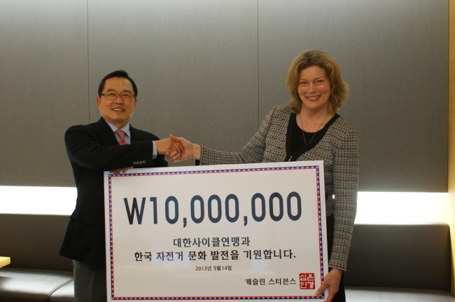 Former U.S. Ambassador to Korea Kathleen Stephens shakes hands with LS Group chairman and Korea Cycling Federation president Koo Ja-yeol after donating 10 million won to the federation on Wednesday.   LS Group