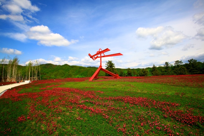 Mark di Suvero’s red steel sculpture “For Gerard Manley Hopkins” stands in the flower garden. Hansol Museum
