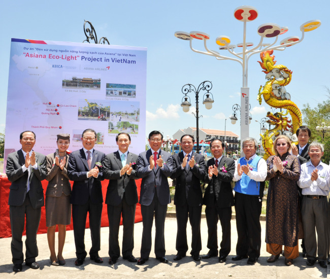 Kumho Asiana Group chairman Park Sam-koo (fifth from left), Asiana Airlines CEO Yoon Young-doo (third from left), Vietnam’s Vice Minister of Planning and Investment Dao Quang Thu (sixth from left) and other guests pose at an event to install solar-powered street lamps at Hoi An Riverside Resort in Da Nang, central Vietnam, Thursday.   Asiana Airlines
