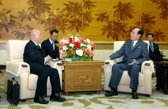 Isao Iijima (left) talks with Kim Yong-nam, North Korea’s titular head of state, in this photo released by Pyongyang’s official Korean Central News Agency on Thursday.   Yonhap News