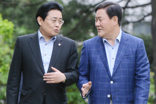 Floor leaders Choi Kyung-hwan (right) of the Saenuri Party and Jun Byung-hun of the Democratic Party walk together before their first formal one-on-one talks at the National Assembly on Sunday.   Park Hyun-koo/The Korea Herald