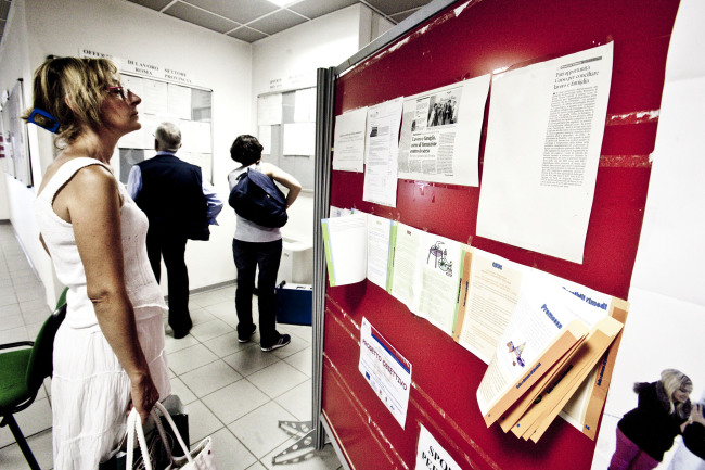 A jobseeker looks through job listings at an unemployment office in Rome.   Bloomberg