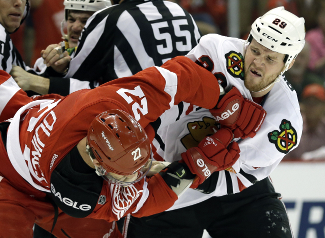 Detroit Red Wings defenseman Kyle Quincey (left) and Chicago Blackhawks left wing Bryan Bickell fight in the first period.   AP-Yonhap News