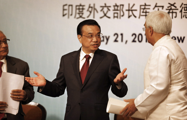 Chinese Premier Li Keqiang (center) gestures as he talks to Indian External Affairs Minister Salman Khurshid (right) at an event organized by Indian Council of World Affairs in New Delhi on Tuesday.    AP-Yonhap News