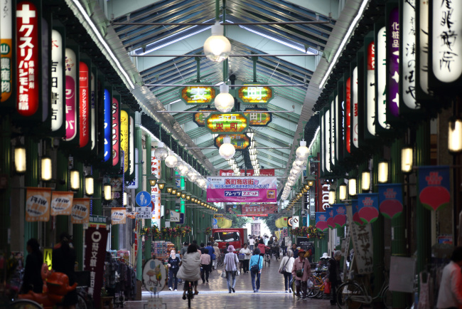 Pedestrians walk through a shopping street in Okayama, Japan, on Tuesday, May 21, 2013. The Bank of Japan, forecast to maintain plans for expanded monetary easing at a meeting ending on May 22, is targeting 2 percent inflation in two years after more than 10 years of entrenched deflation. Photographer: Tomohiro Ohsumi/Bloomberg
Pedestrians walk through a shopping street in Okayama, Japan.   Bloomberg