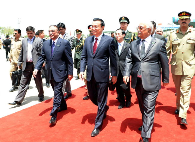 Chinese Premier Li Keqiang (center) is welcomed by Pakistani President Asif Ali Zardari (left) and interim Prime Minister Mir Hazar Khan Khoso (right) upon his arrival in Islamabad on Wednesday.   Xinhua-Yonhap News