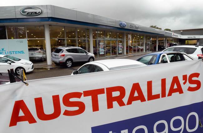 Signs adorn a Ford dealership in Sydney, after Ford announced it will cease making vehicles at its unprofitable Australian plants in 2016 and axe 1,200 jobs, having produced its first car in the country in 1925.   AFP-Yonhap News