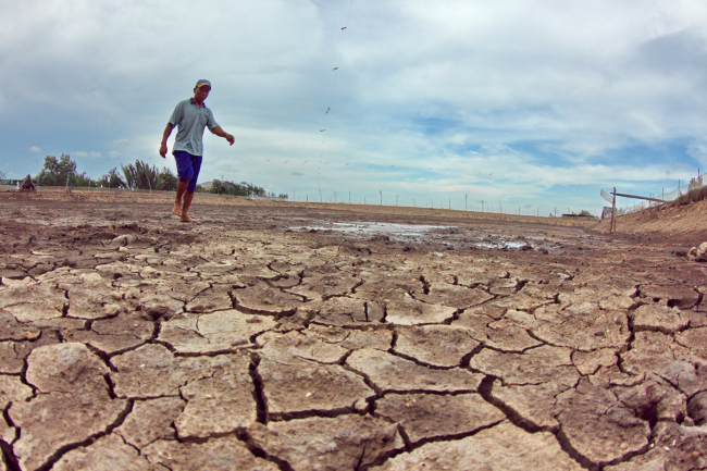 A farmer walks on a dried shrimp pond in the Mekong Delta region of Vietnam, which is one of the most vulnerable locations to the impacts of climate change including severe flooding, droughts, tropical storms and erosion along the sea embankments.   Xinhua-Yonhap News