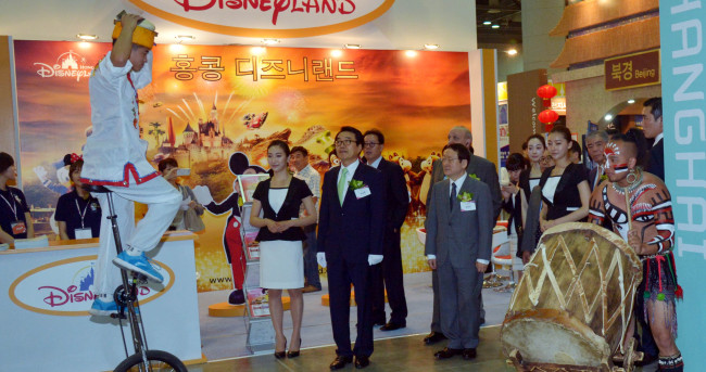 Korea Tourism Association Chairman Nam Sang-man (third from left) and HanaTour CEO Park Sang-hwan (second from left) look around the Chinese Pavilion of the HanaTour International Travel Show 2013 at KINTEX in Goyang, Gyeonggi Province, Friday. The expo presents various travel destinations and packages and will be held through Sunday.   Kim Myung-sub/The Korea Herald