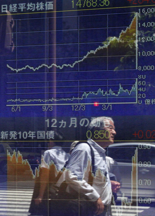 Pedestrian are reflected in an electronic stock board in Tokyo on Friday.   Bloomberg