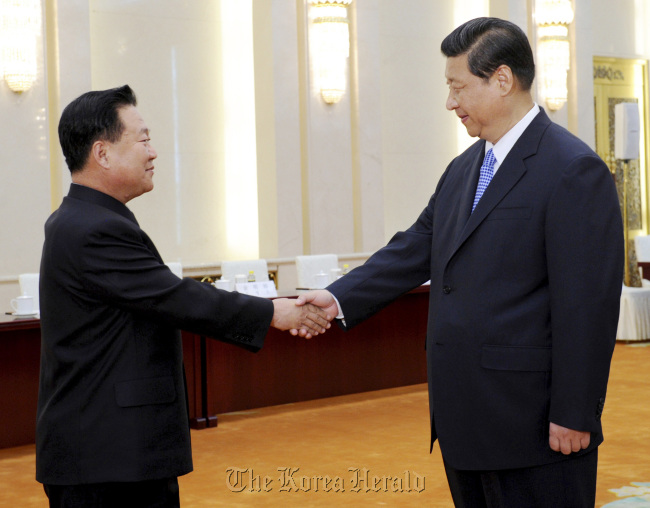 Chinese President Xi Jinping (right) shakes hands with North Korean Vice Marshal Choe Ryong-hae in Beijing on Friday. (AP-Xinhua-Yonhap News)