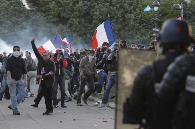 Riot police officers (foreground) face anti-gay marriage demonstrators during clashes in Paris on Sunday.   AP-Yonhap News