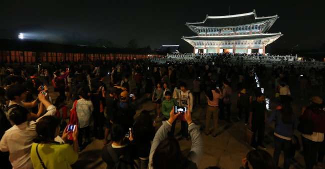 A large crowd gathers inside Gyeongbokgung Palace in downtown Seoul on Wednesday night, the first night this year for the palace to be open for public viewing.   Yonhap News