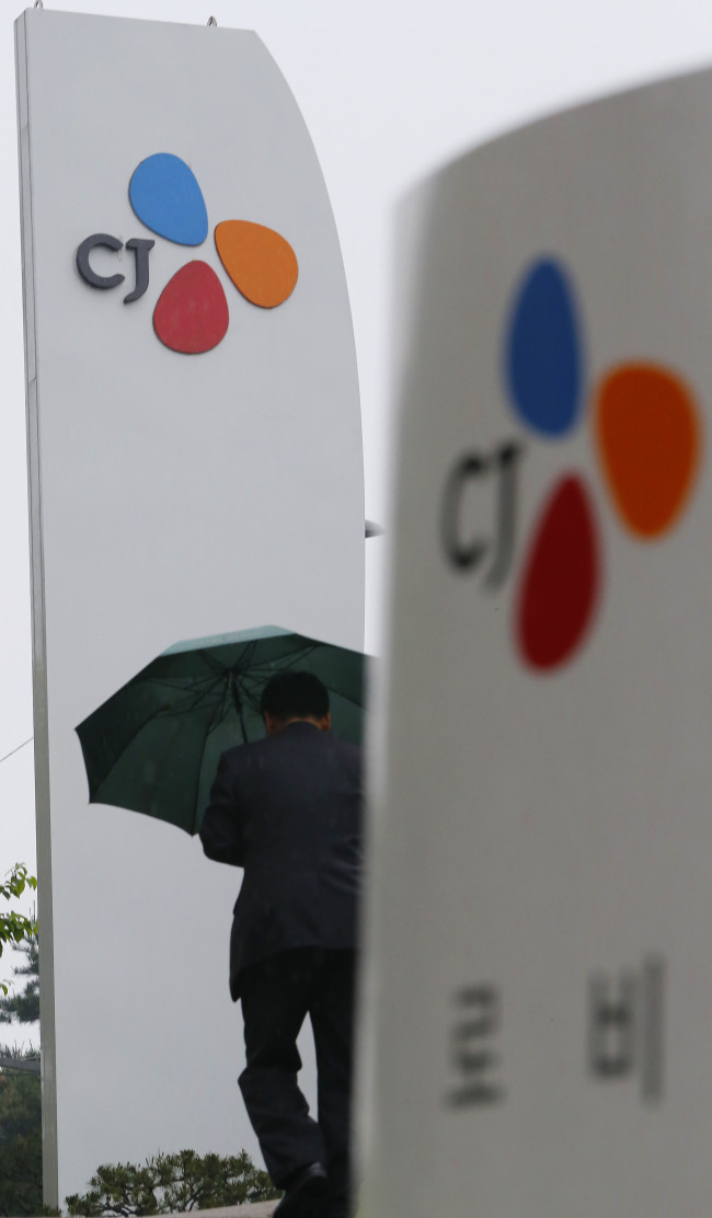 A CJ employee walks along outside the group headquarters in Seoul on Tuesday.   Yonhap News