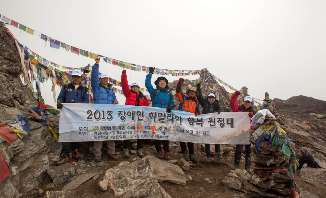 <YONHAP PHOTO-0696> 장애인 행복원정대 히말라야 5천380ｍ 등정 (성남=연합뉴스) 예비사회적기업 ㈜수레는 '장애인 히말라야 행복원정대'가 28일 오전 8시께 해발 5천380ｍ 네팔 히말라야 고쿄리(Kokyo-Ri) 정상을 등정했다고 30일 밝혔다. 왼쪽 세번째부터 다운증후군 장애우 김창일(20)씨의 어머니 최영미(53)씨, 자폐 장애우 김동현(19)군과 동현군 아버지 김성재(46)씨 창일씨는 해발 3천440ｍ 남체까지 갔으나 고소 증세로 정상에 함께 오르지 못했다. <<㈜수레 제공, 지방기사 참조>> 2013.5.30 ktkim@yna.co.kr/2013-05-30 10:20:27/ <저작권자 ⓒ 1980-2013 ㈜연합뉴스. 무단 전재 재배포 금지.>
An expedition team, including a disabled man, poses at a 5,380-meter peak in the Himalayas, Nepal, on Tuesday.   Yonhap News