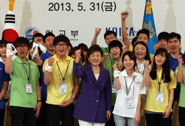 President Park Geun-hye and members of World Friends Korea gesture during the ceremony to launch this year’s activity of the government-supported overseas volunteer group at Cheong Wa Dae on Friday.   Yonhap News