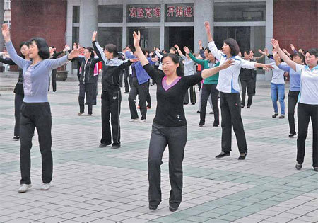 Locals of Zhouqu, Gansu province, dance during a morning session. China Daily