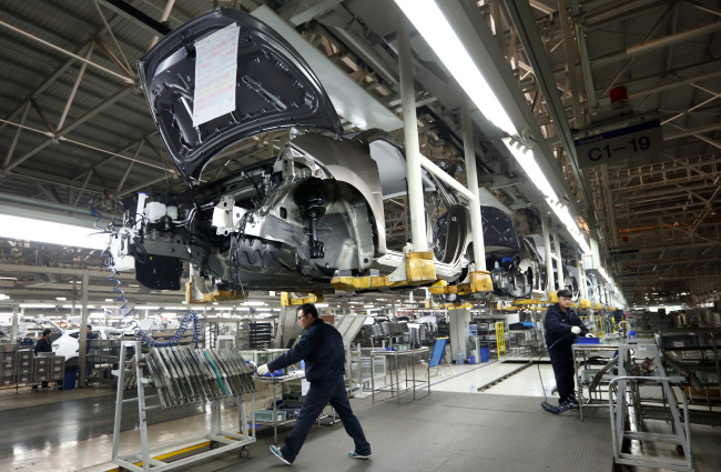Workers assemble Beijing Hyundai Motor Co. cars on the production line at the company’s plant in Beijing.   Bloomberg