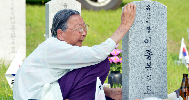 A woman grieves at the tomb of a fallen soldier at Seoul National Cemetery in southern Seoul on Wednesday, a day before Memorial Day.
Kim Myung-sub/The Korea Herald