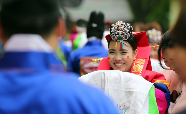 A bride goes through a group Korean traditional wedding ceremony at Seocho Culture and Arts Park in southern Seoul on May 22. The event was held for migrant spouses who did not have a wedding ceremony.   Yonhap News
