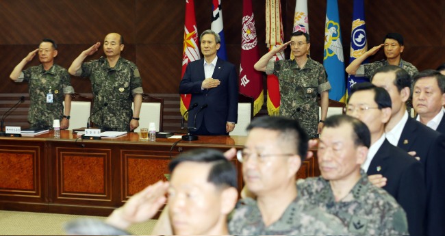 Defense Minister Kim Kwan-jin (third from left), Joint Chiefs of Staff Chairman Jung Seung-jo (second from left) and others salute the national flag at a meeting of top military commanders at the ministry in Seoul on Friday.   Kim Myung-sub/The Korea Herald