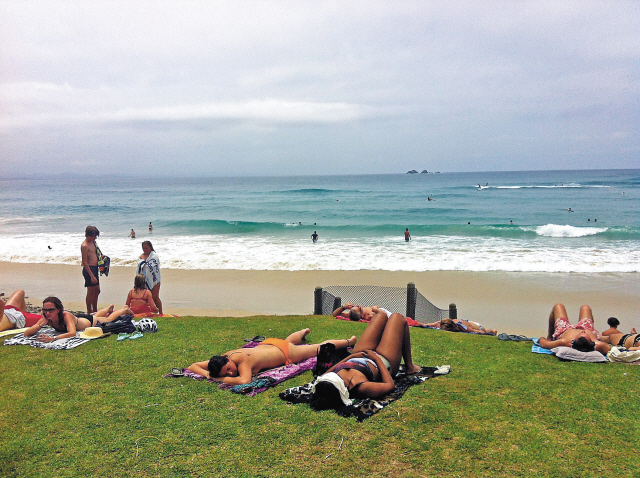 Swimmers get some sun on the grass above Main Beach in Byron Bay, Australia, which is directly in front of town. (Los Angeles Times/MCT)