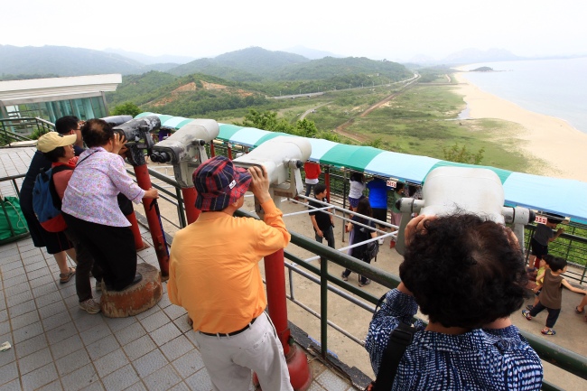 Caption: South Koreans look to the North from an observation post near the Demilitarized zone Friday. (Yonhap News)