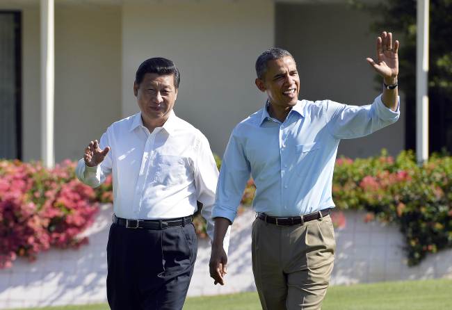 U.S. President Barack Obama (right) and Chinese President Xi Jinping wave as they take a walk at the Annenberg Retreat at Sunnylands in Rancho Mirage, California, Saturday.   AFP-Yonhap News
