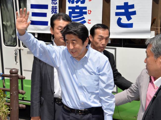 Japanese Prime Minister Shinzo Abe waves to his supporters after delivering a speech for the Tokyo Metropolitan Assembly election in Tokyo on Sunday. AFP-Yonhap News