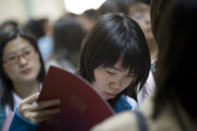 Attendees of a job fair sponsored by Beijing Technology and Business University wait to speak with a recruiter in Beijing.   Bloomberg