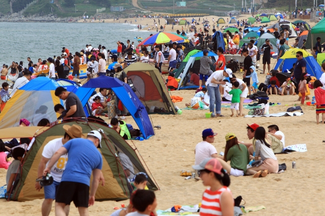 Holidaymakers enjoy the sun at the beach in Sokcho, Gangwon Province.   Yonhap News
