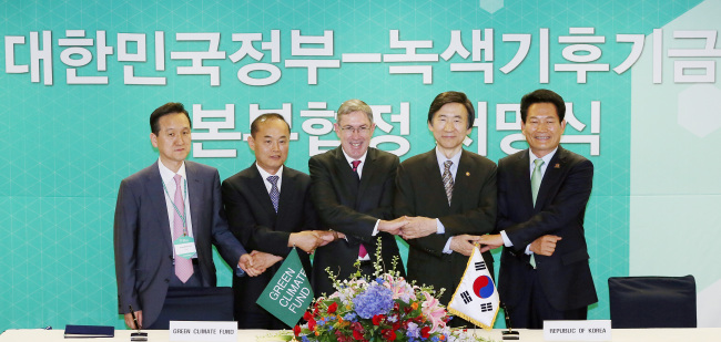 Foreign Minister Yun Byung-se (second from right), and Green Climate Fund co-chairman Ewen McDonald (center), Incheon Mayor Song Young-gil (right) and other officials pose after signing an agreement to establish the U.N. agency’s headquarters in the city’s business district of Songdo.   Yonhap News