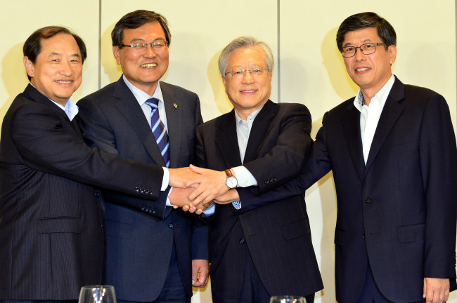 Science Minister Choi Mun-kee (second from left) and the three CEOs of Korea’s telecommunications firms ― Lee Sang-chul (left) of LG Uplus, Lee Suk-chae (second from right) of KT and Ha Sung-min of SK Telecom ― shake hands at a meeting in Seoul on Monday.   Yonhap News