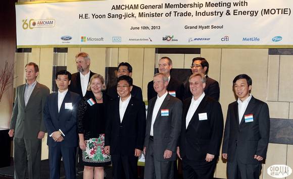 Industry Minister Yoon Sang-jick (fourth from left, front row) and AMCHAM Korea chairman Pat Gaines (fifth from left, front row) pose with chamber members during a meeting on foreign investment in Seoul on Monday.   Courtesy Ilyo Sisa